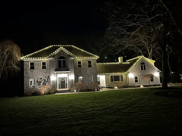 Warm white roofline lighting on a home in Canton, MA