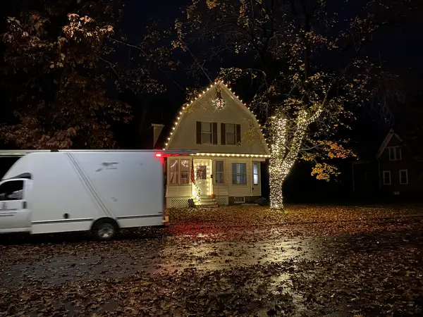 Warm white roofline lighting on a home in Claremont, NH