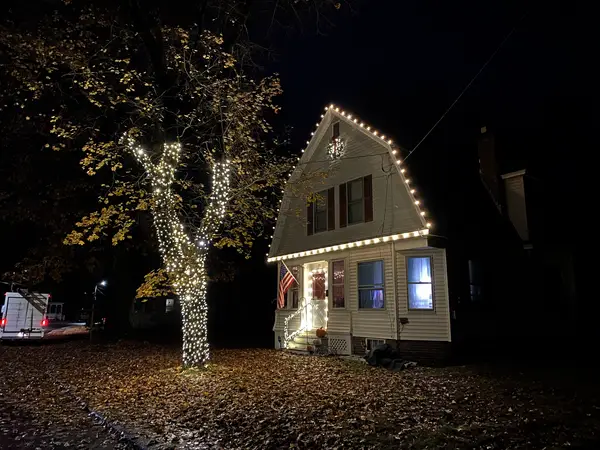 Warm white roofline lighting on a home in Claremont, NH