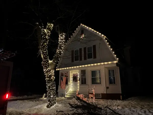 Roofline, bushes and walkway lit in Claremont, NH