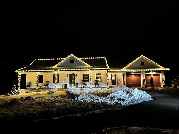 Warm white roofline lighting on a home in Foxborough, MA