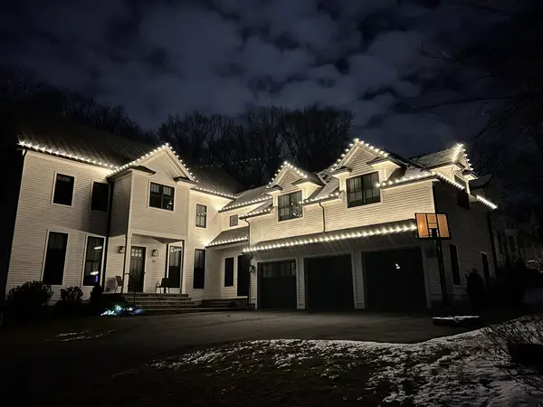 Warm white roofline lighting on a home in Lexington, MA