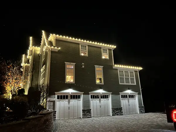 Warm white roofline lighting on a home in Middleton, MA