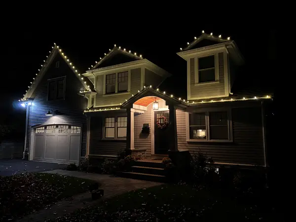 Warm white roofline lighting on a home in Newton, MA