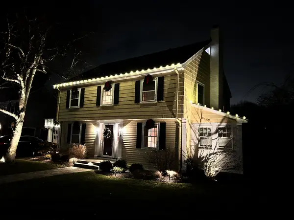 Roofline, bushes and walkway lit in Newton, MA