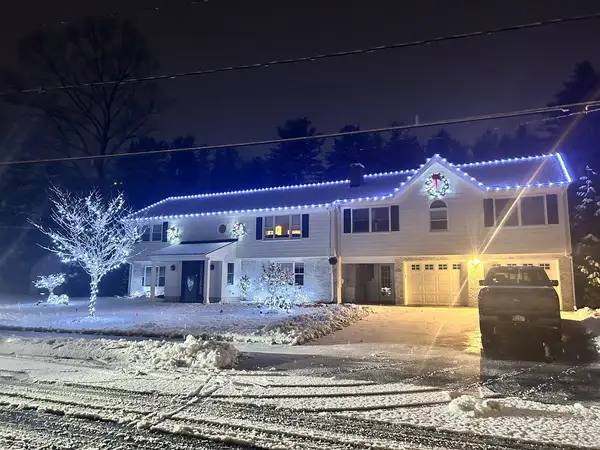 Warm white roofline lighting on a home in North Reading, MA