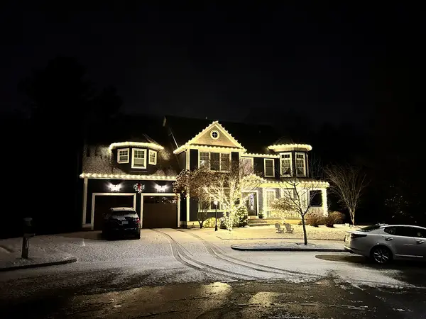 Warm white roofline lighting on a home in Reading, MA
