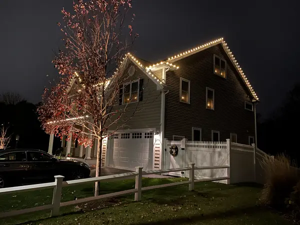 Warm white roofline lighting on a home in Woburn, MA