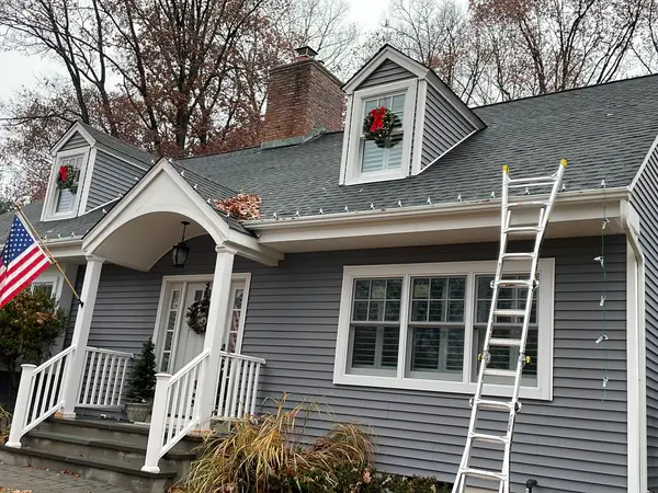Holiday Lights Decor crew installing Christmas lighting from a lift